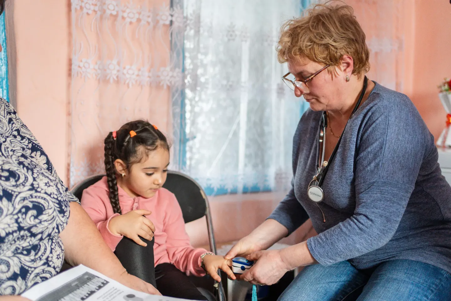 Lăcrămioara Vr&acirc;nceanu, a community nurse, measures Antonia&rsquo;s pulse and oxygen saturation during a home visit in February 2024. Antonia has a history of pneumonia complications and must receive careful health screenings in order to stay healthy.