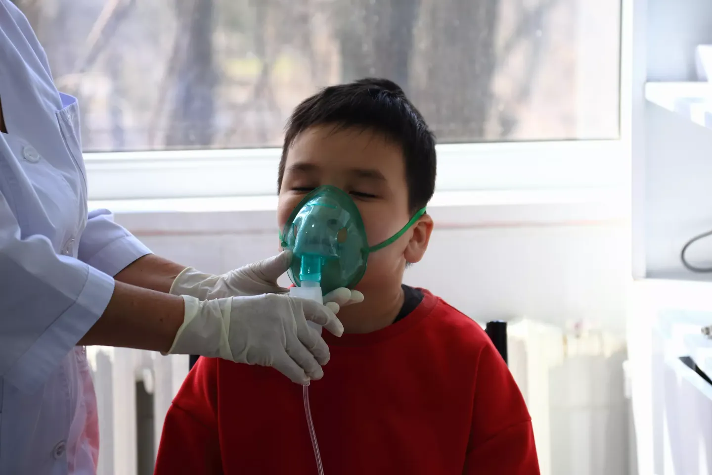 A boy breaths through an oxygen mask. 