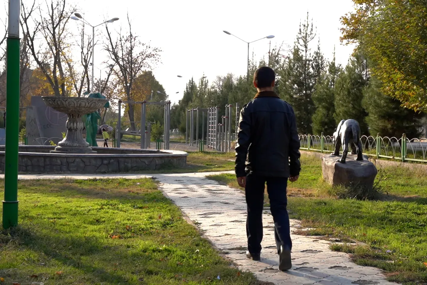 R.R. 17, walks through a park in Dushanbe, Tajikistan. With little support from his community, and facing the challenges of stigma after being released from a detention facility, R.R. is now taking part in a support programme run by UNICEF that provides him with the guidance, education and psychosocial support he needs to rebuild his life and reintegrate into society. November 2022.