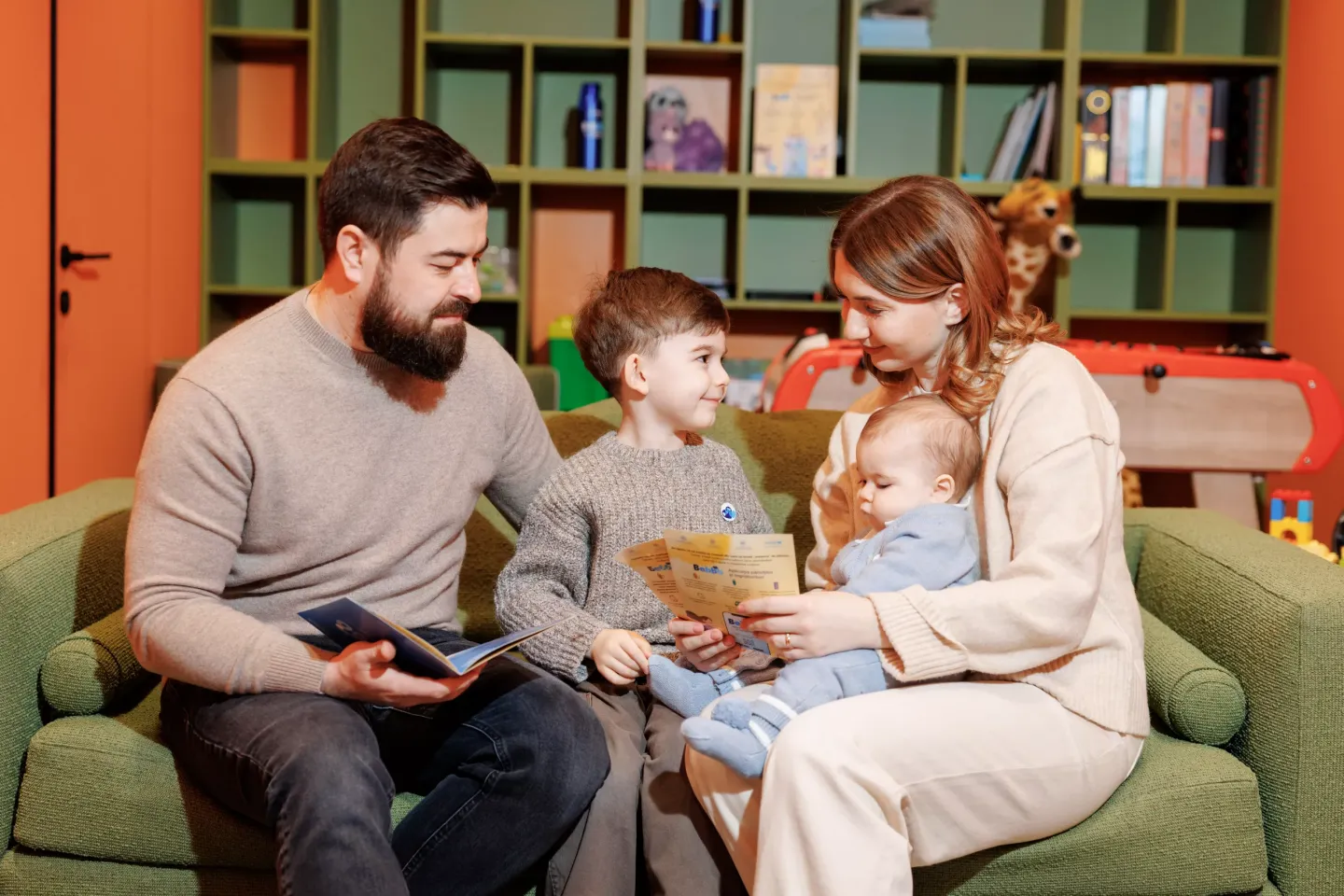A family sits on their couch.