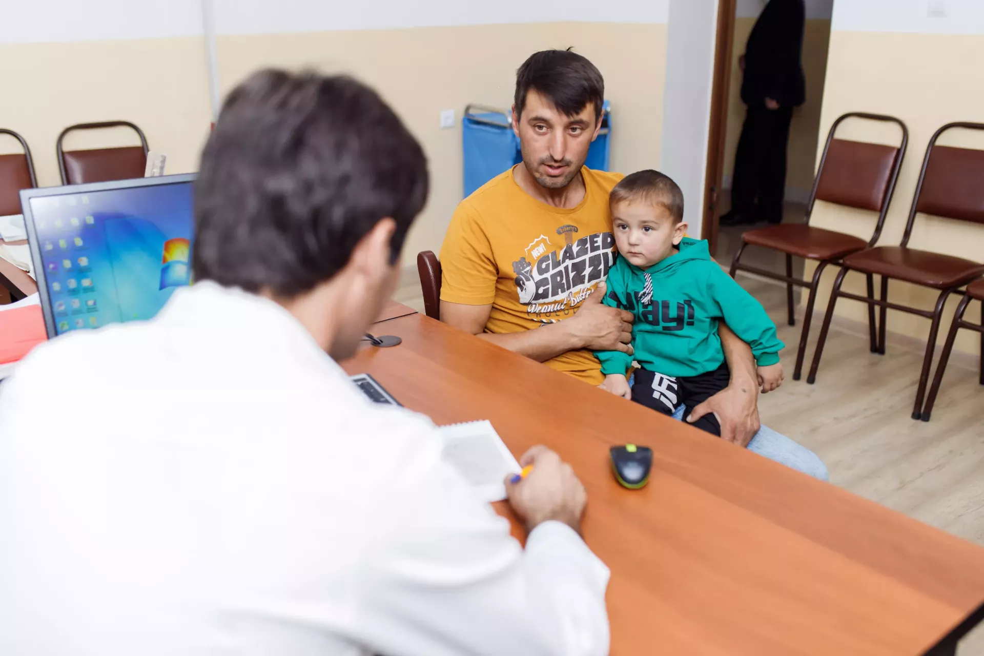 Iskandar, aged 3, and his father at the district health centre in Khovaling, Tajikistan, where Iskandar will be weighed. The boy is underweight for his age, and his concerned father has come to get advice from the family doctor.