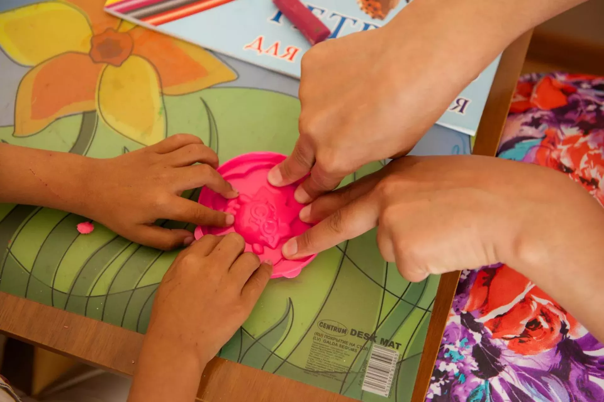 Nazokat, a social worker, assists Firdavs play with play-dough at the Daycare Centre for living with HIV children and families affected by HIV in Tashkent City AIDS Centre.
