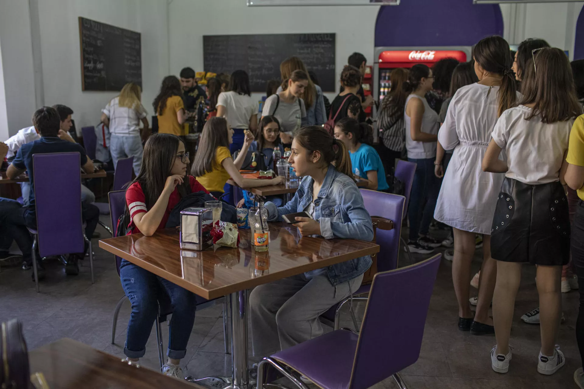 Adolescent girls are eating in the university canteen. 
