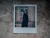 Polaroid picture from Nika's (11) photo album of memories, showing her next to the window, barricaded with sandbags, waiting for the air alarm to end at the shelter of Child Spilno Spot.