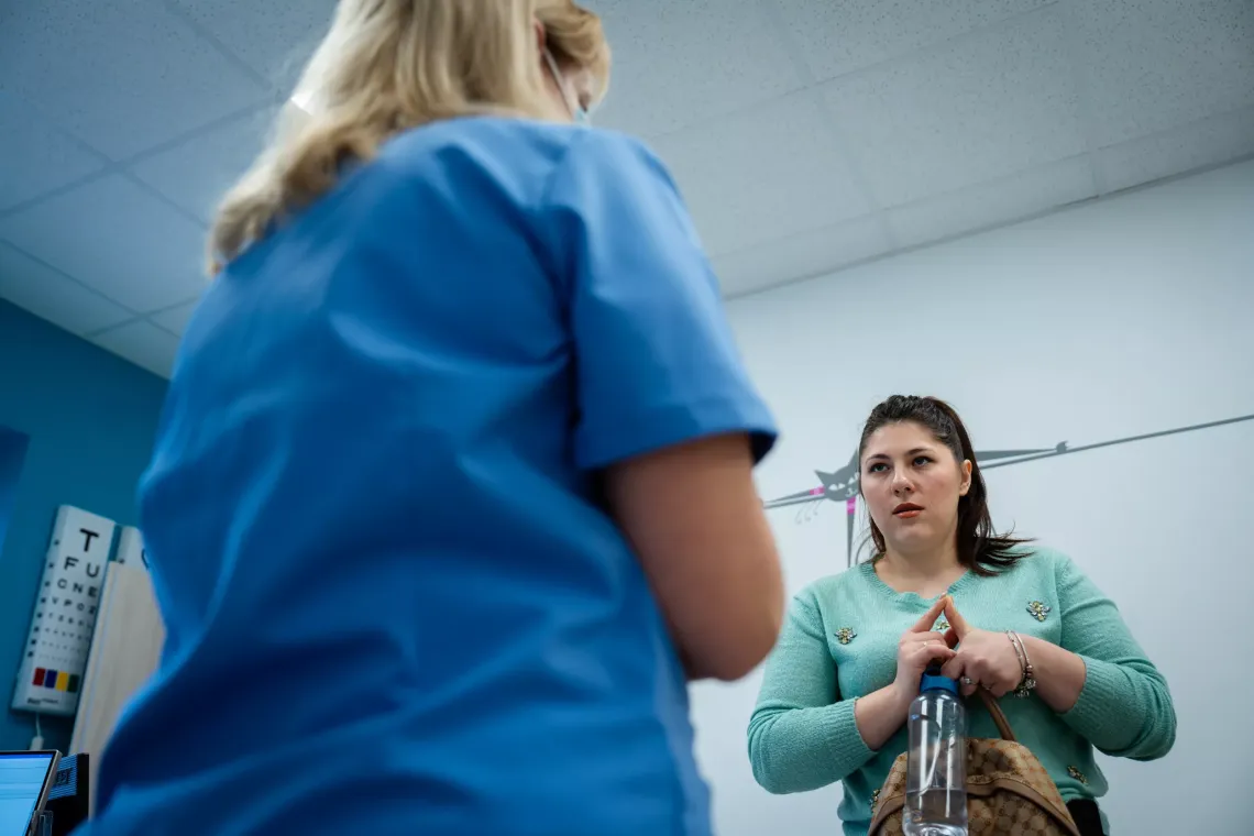 Tatiana, a Ukrainian pediatrician, speaks to a mom of her patient.