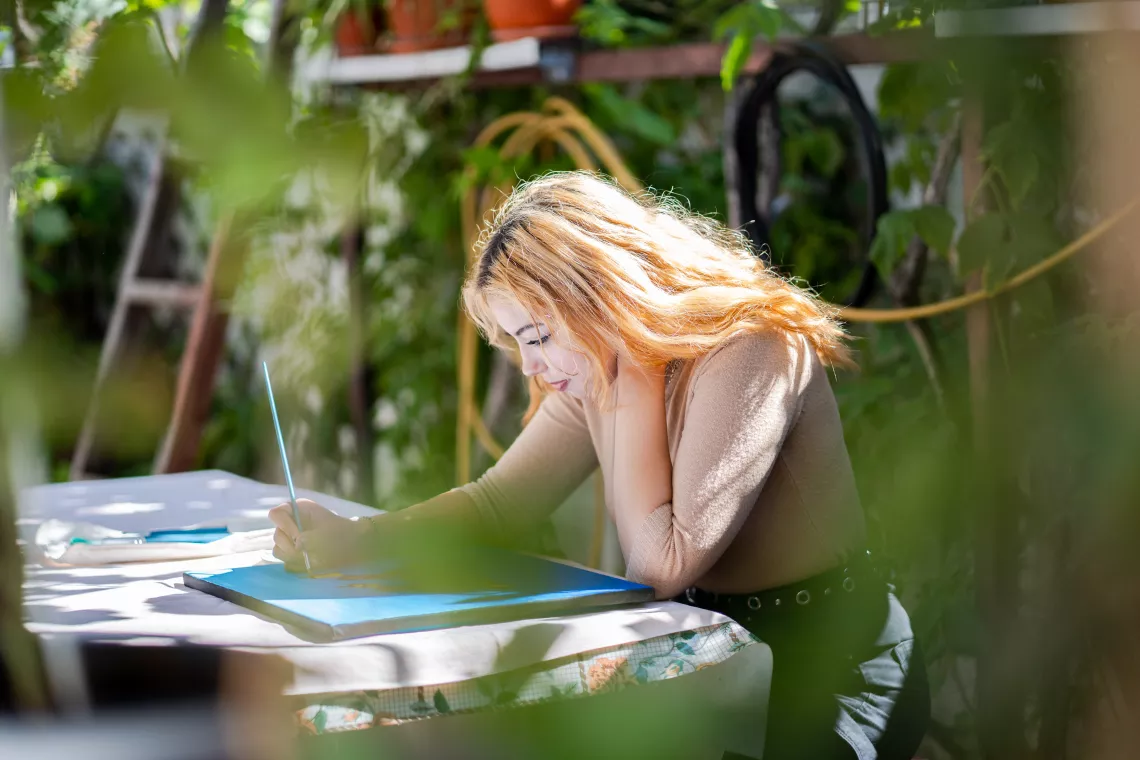 Gabriela paints in the patio of her grandparents&rsquo; house. 