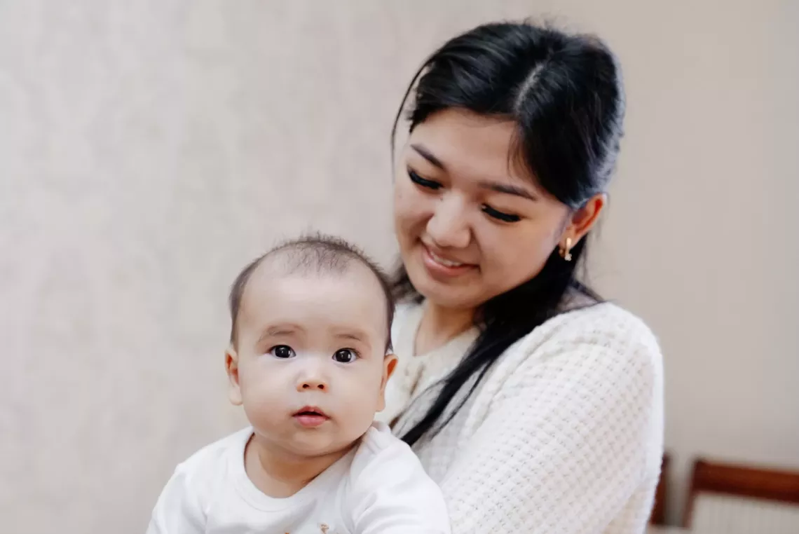 A home visiting nurse holds a baby