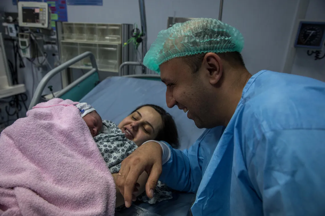 Arslan, 38 (father) smiles as he sits by his wife, Alina 33 and their new baby boy, Damir at the Maternity Unit, Mother and Child Health Centre in Ashgabat.