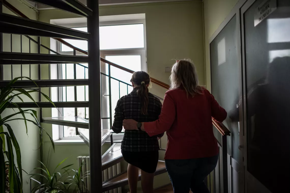 Liza speaks to a social worker while visiting the shelter, several months after she had stayed there.