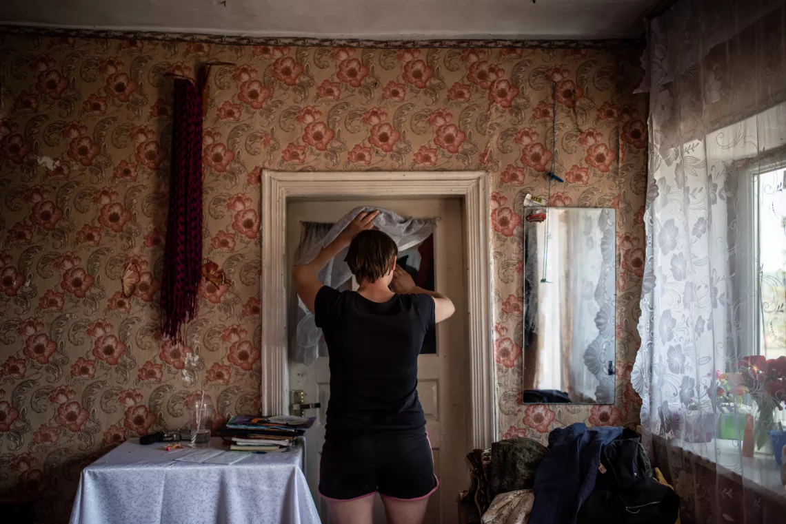 Silvia cleans a window at her small home in Moldova.
