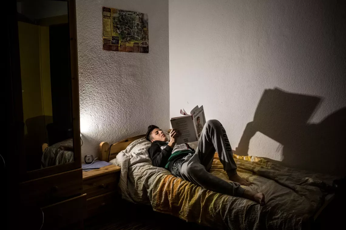 Ahmad, 16, works on his homework at night in his bedroom at a youth residence in Peine, Germany. Ahmad, a Lebanese Palestinian refugee traveled alone from Lebanon to Germany with his brother. September 2016
