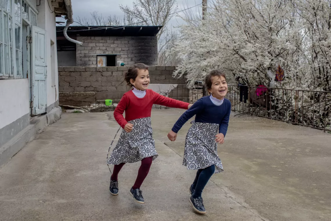 Children are more likely to be physically active when they are playing outdoors, rather than indoors &ndash; as these twin sisters, Magfirat and Marifat, show outside their home in Rajab Ismoil jamoat, Tajikistan in March 2022. 