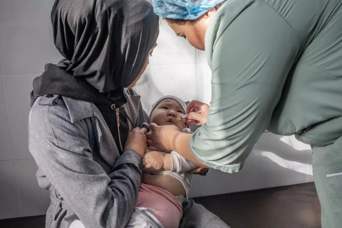 11-month-old Mariam Amirbekova is held by her mother as she receives her second dose of pentavalent vaccine from Nurse Aychurek Makombaeva, 38, at Family Medicine Centre location number 7 in Bishkek. Kyrgyzstan. November 2022