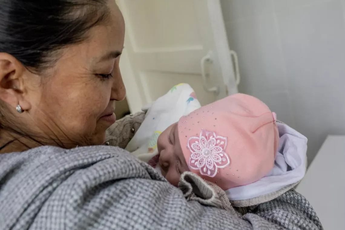 Mother Gulsana holds her two-month-old   daughter, Asiya, who has just received her routine  immunizations in Kyrgyzstan. November 2022.