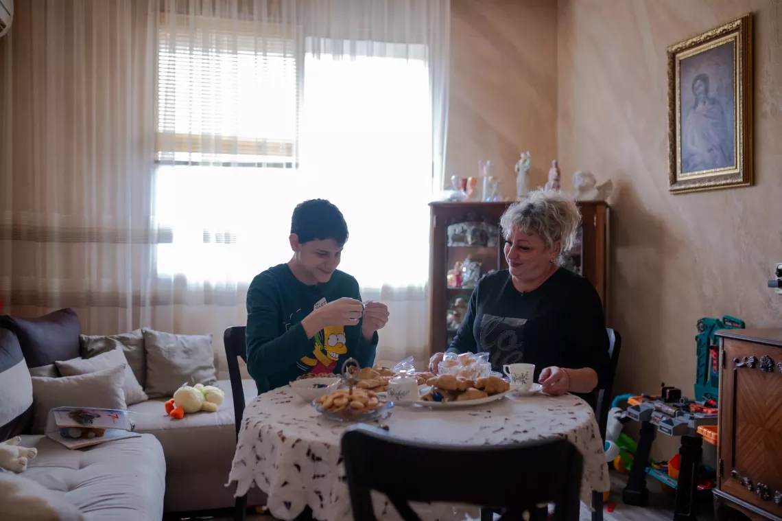 Vladi, aged 13, with his foster mother, Petya Panosyan, at their home in Shumen, Bulgaria. January 2024.