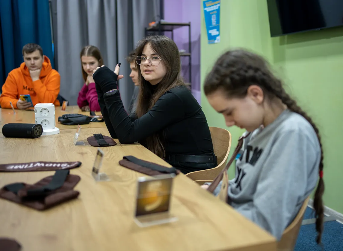 Nika (11) from Kharkiv is sitting next to other teenagers in UNICEF Child Spilno Spot. 