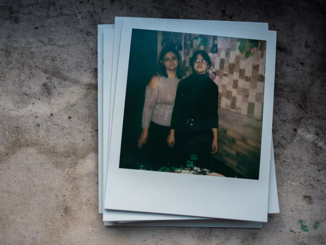 Polaroid picture from Nika's (11) photo album of memories, showing her, standing next to her mother on their kitchen.