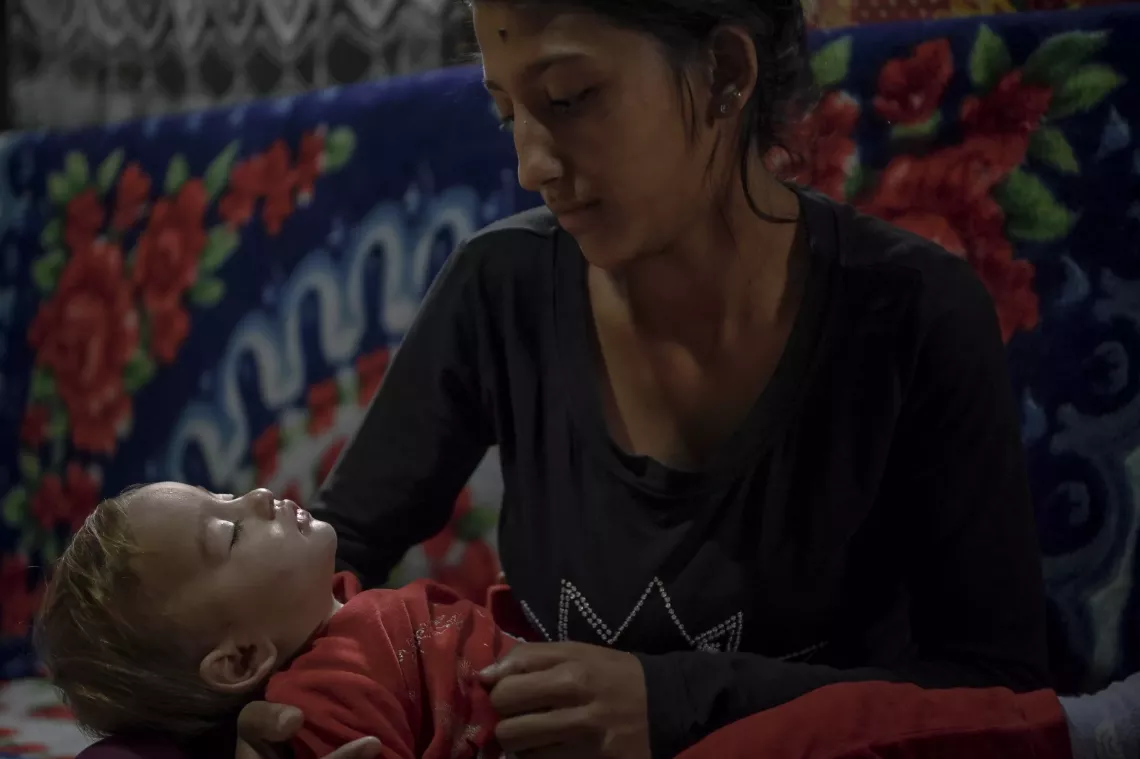 Leontina, 19, holds her Daughter, Songjul, 1, inside their shelter at the Gazi Baba settlement in Skopje, North Macedonia on March 13, 2024.