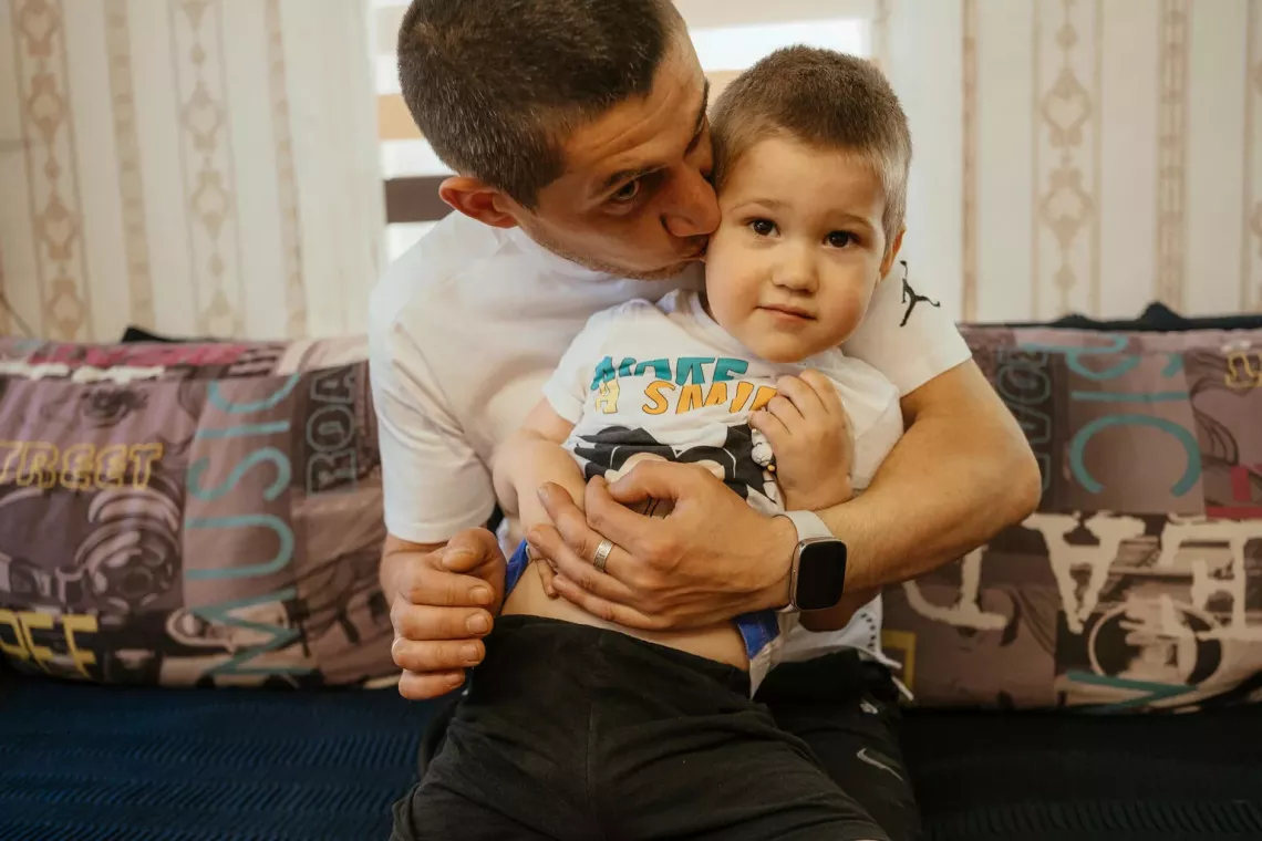 Yevhen kisses his three-year-old son, who has ASD, in this picture taken in May 2024. Like all children, those with ASD need loving, nurturing care in order to thrive.