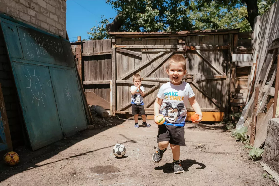 Three-year-old twin brothers Bohdan and Matvii play football in their yard in May 2024. Both have been diagnosed with ASD and have benefited from sessions with special education teachers.