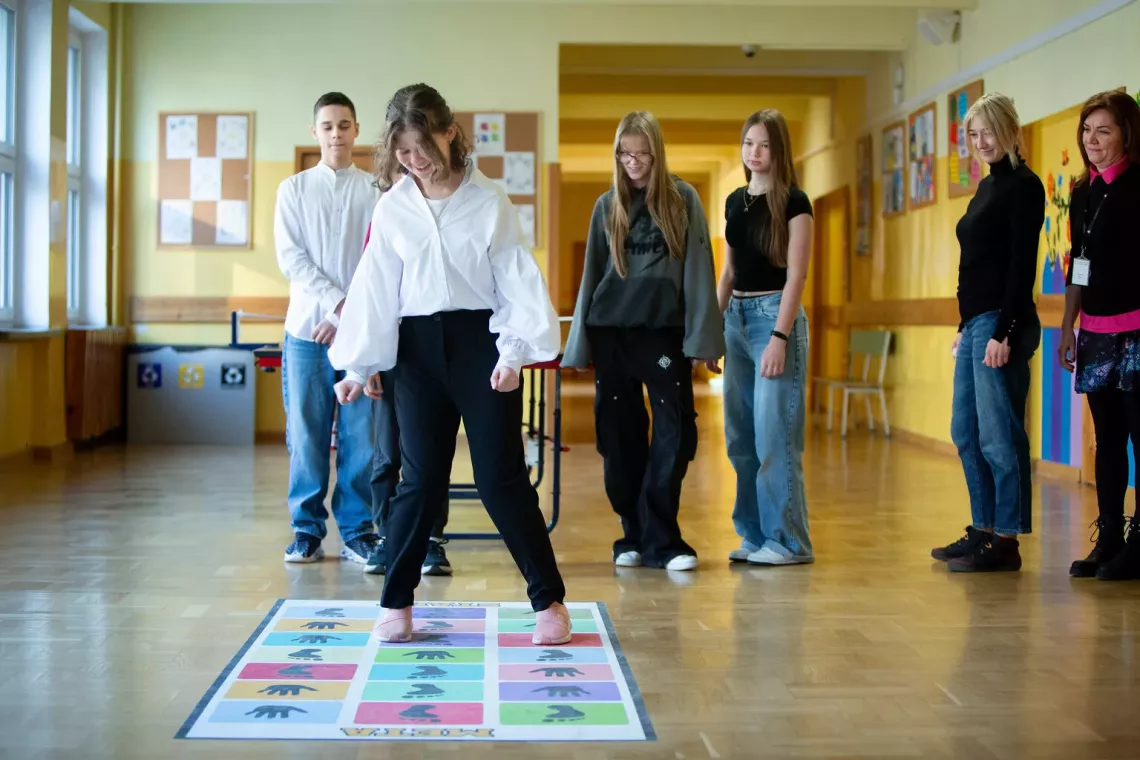 Teachers Teresa and Marta together with their pupils Ivan, Kseniia, Zofia, Julia, participants of UPSHIFT programme at their primary school 258 in Warsaw playing together using hopscotch decal.