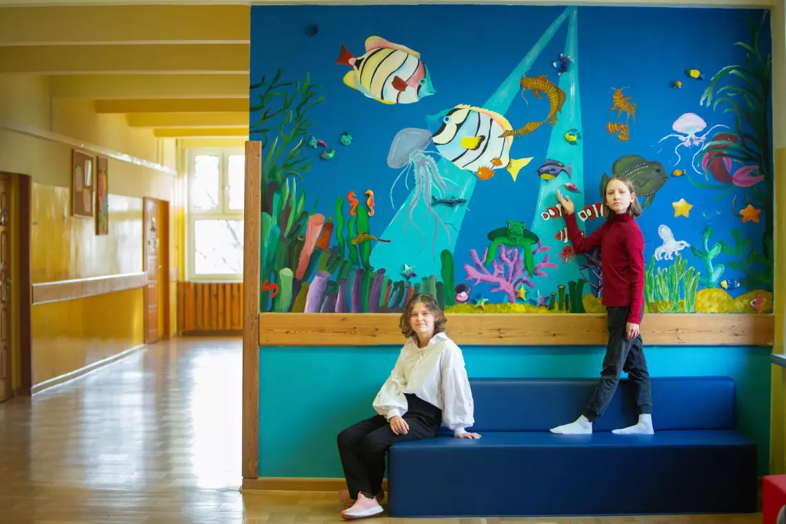 Kseniia from Ukraine and Yan the UPSHIFT programme at their primary school 258 in Warsaw presenting the mural their team designed and created during the programme.
