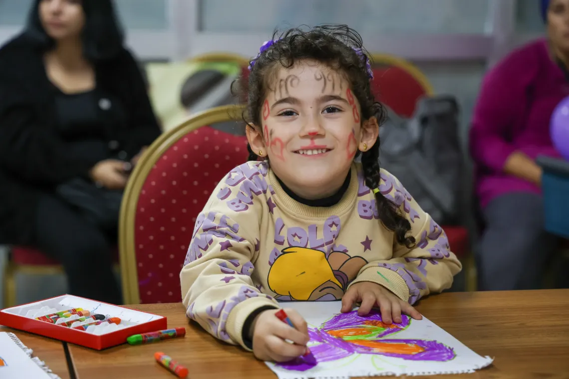 A child smiles at the camera at an Awareness Training Program on Strengthening and Developing Children&rsquo;s Life Skills was held in Osmaniye. During the event, experts informed participating parents about the topic, while children took part in various engaging activities.