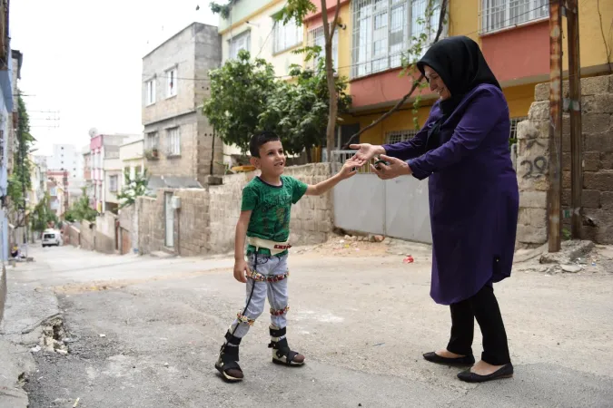 A child walks with the help of leg braces.