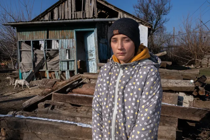 Yana, 14, draws water from a well near her destroyed home in the village of Kobzartsi, Mykolaiv region, Ukraine.