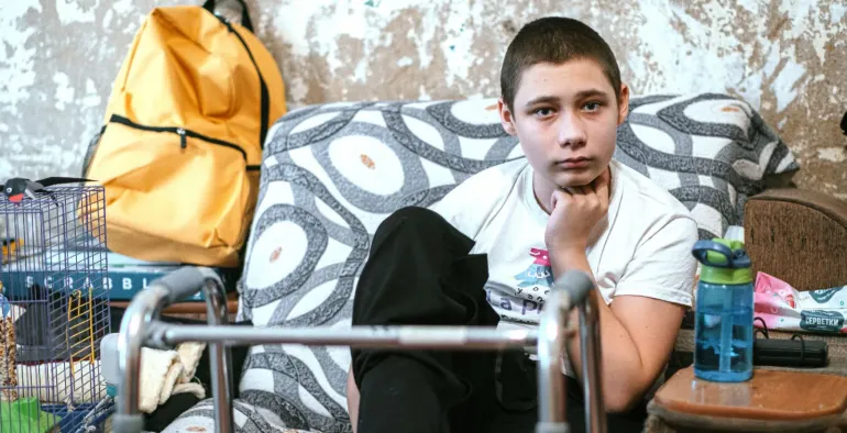 Profile of an adolescent boy sitting on a chair