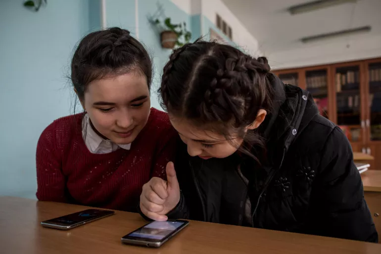 Aliya, age 13, (right) with her classmates before her class in Aktau, Kazakhstan, on 16 March 2018.