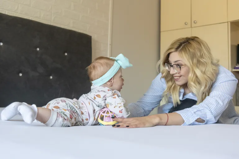 A mother and her baby playing.
