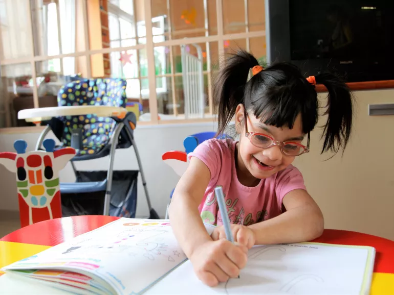 In Serbia, a girl, who has a disability, completes a learning exercise at the Zvecanksa Street centre, in Belgrade, the capital.