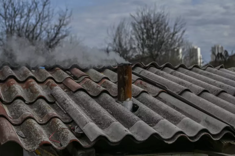Smoke comes out of a chimney of a shelter at the Gazi Baba settlement in Skopje, North Macedonia