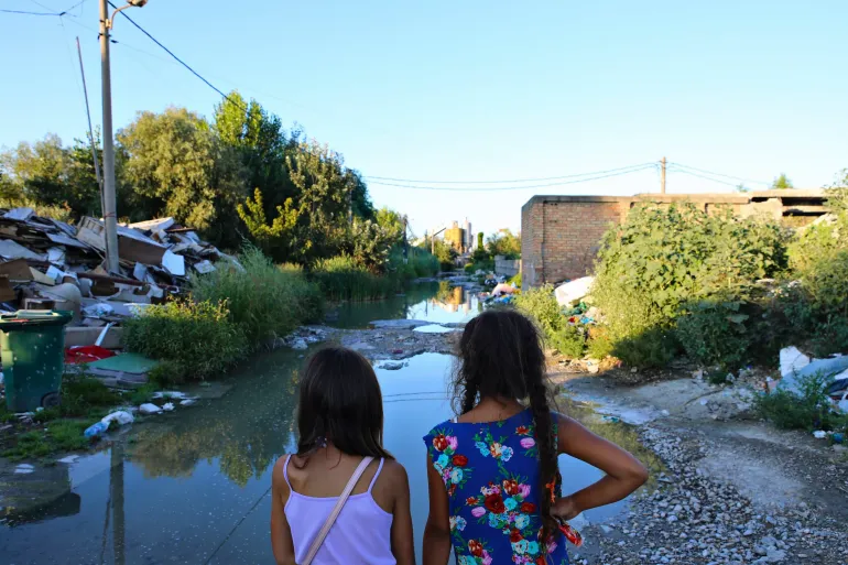 Two Roma girls are looking at sewage water close to their homes in Vuka Vrcevica Deponija settlement, in Belgrade, Serbia.