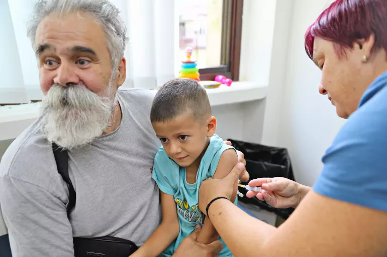 6-year-old Luka from Belgrade, Serbia, sitting on a lap of his grandfather, Todor while he receives a vaccine shot at the Zemun Primary Health Centre in Belgrade, Serbia