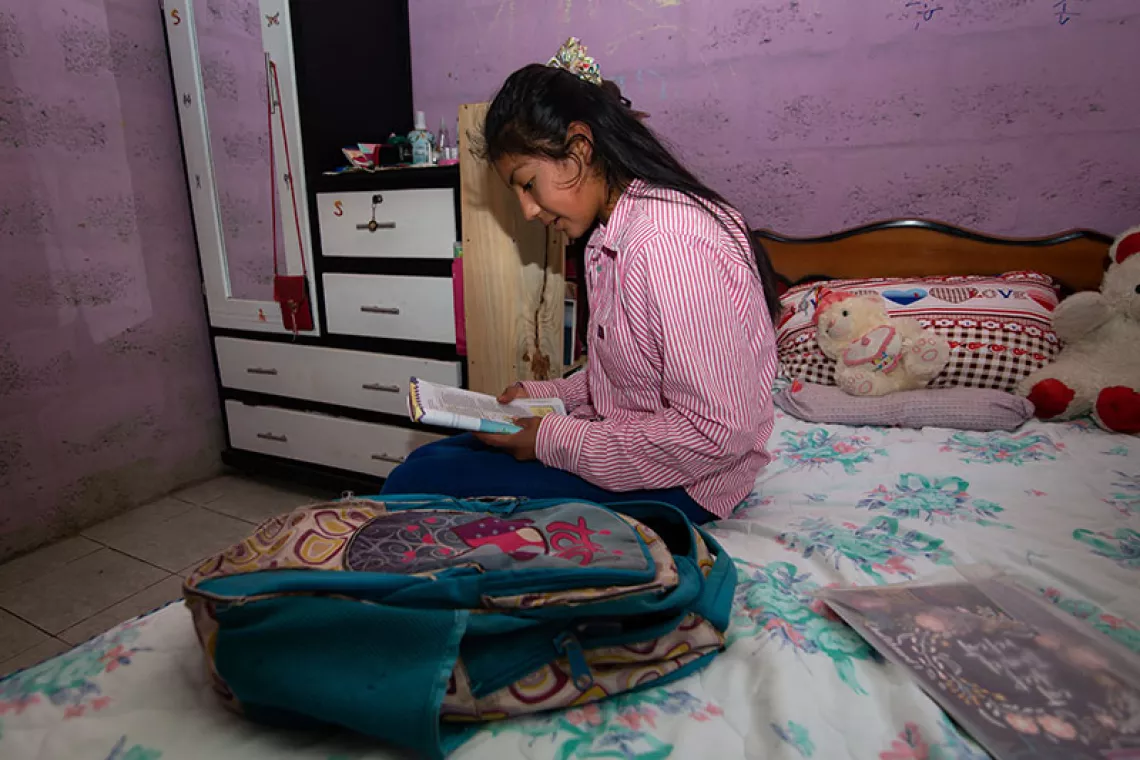 Margarita leyendo sus cuadernos escolares
