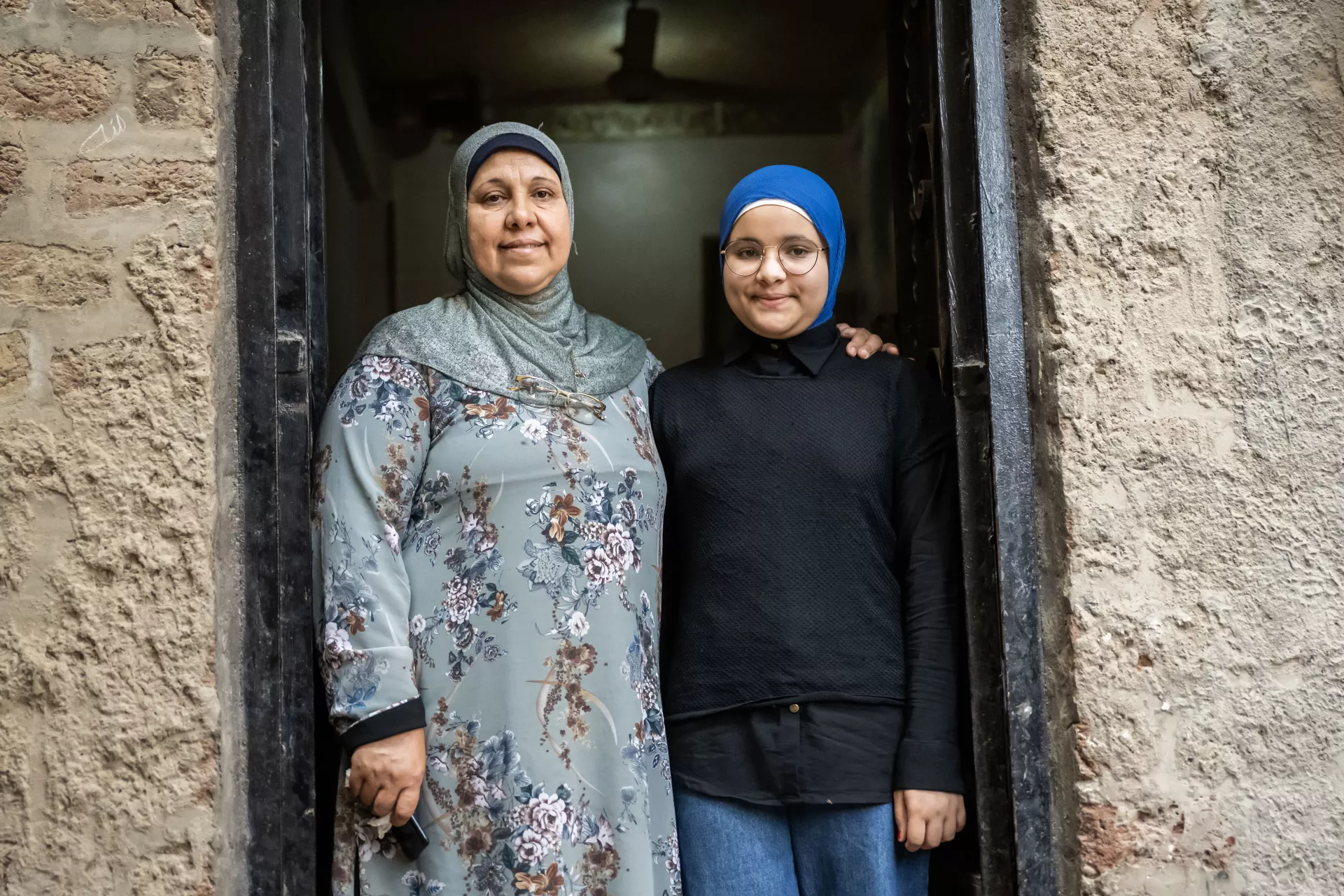 Girl Smiling in doorway with her mother