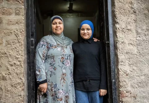 Girl Smiling in doorway with her mother