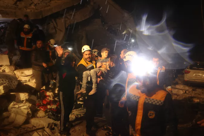 On 6 February 2023, rescue workers carry a boy they recovered from the rubbles of a building after an earthquake in Dana, rebel-held Idlib, Syrian Arab Republic.