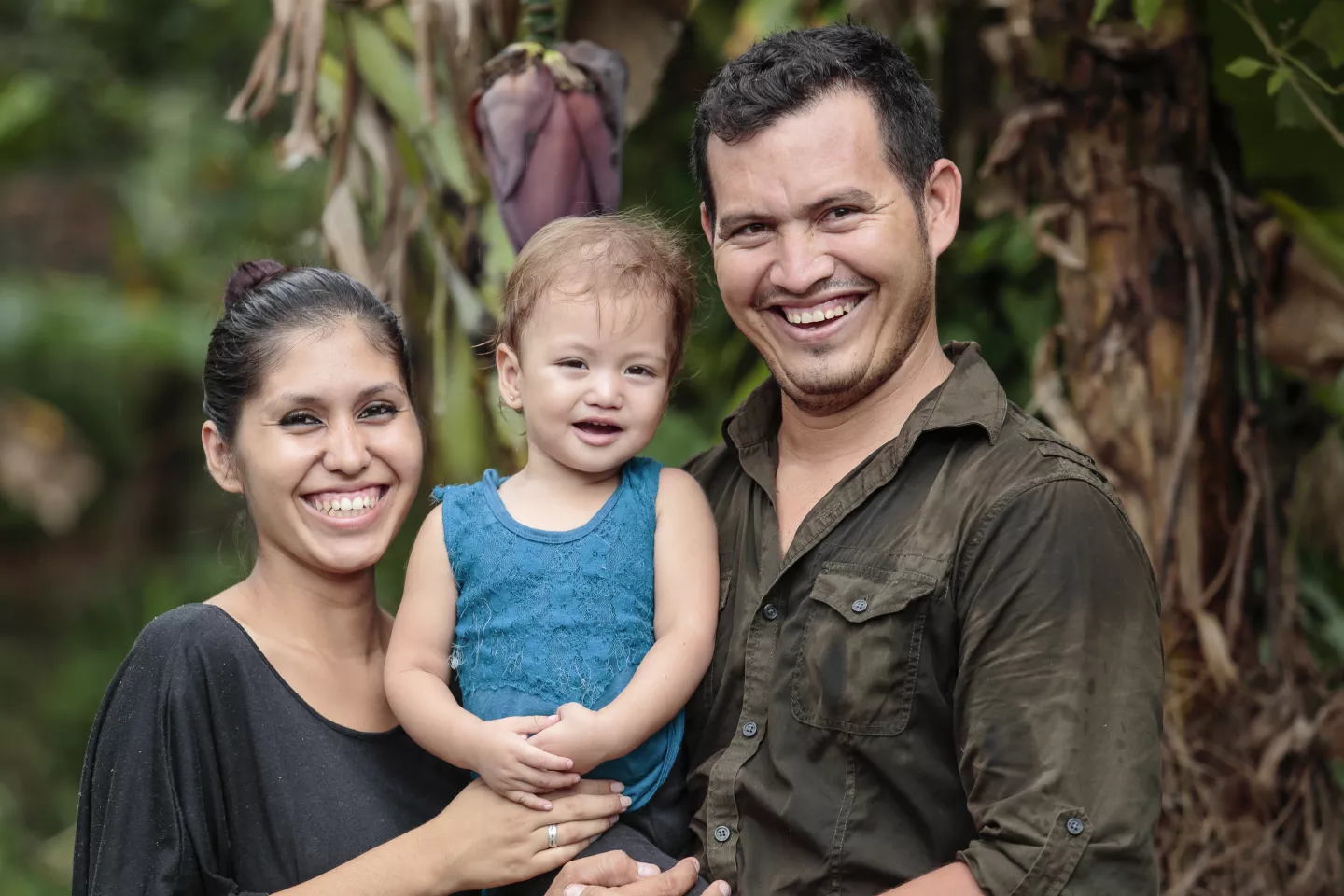 Familia de Chalatenango conformada por padre, madre e hija sonrien para una fotograf&iacute;a