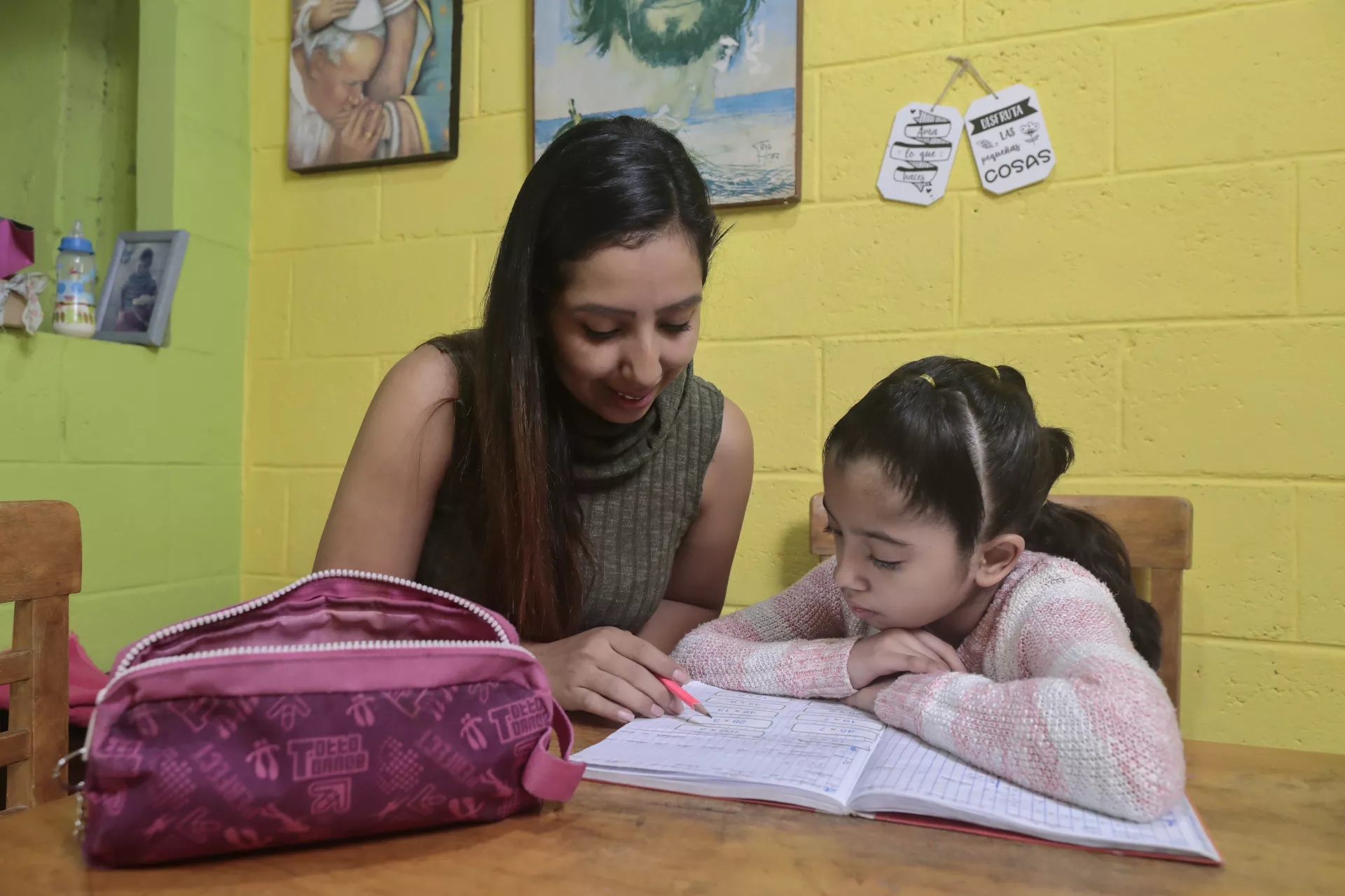Ni&ntilde;a de nueve a&ntilde;os hace sus tareas con la ayuda de su mam&aacute;, durante la pandemia de COVID-19