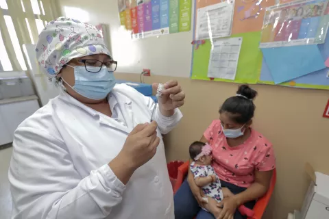 Mamá  esperan a la especialista que aplicará las vacunas a su hija en la clínica.
