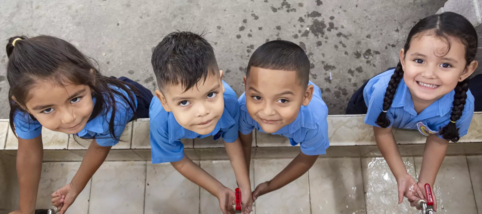 Ni&ntilde;os y ni&ntilde;as de parvularia en El Salvador se lavan las manos