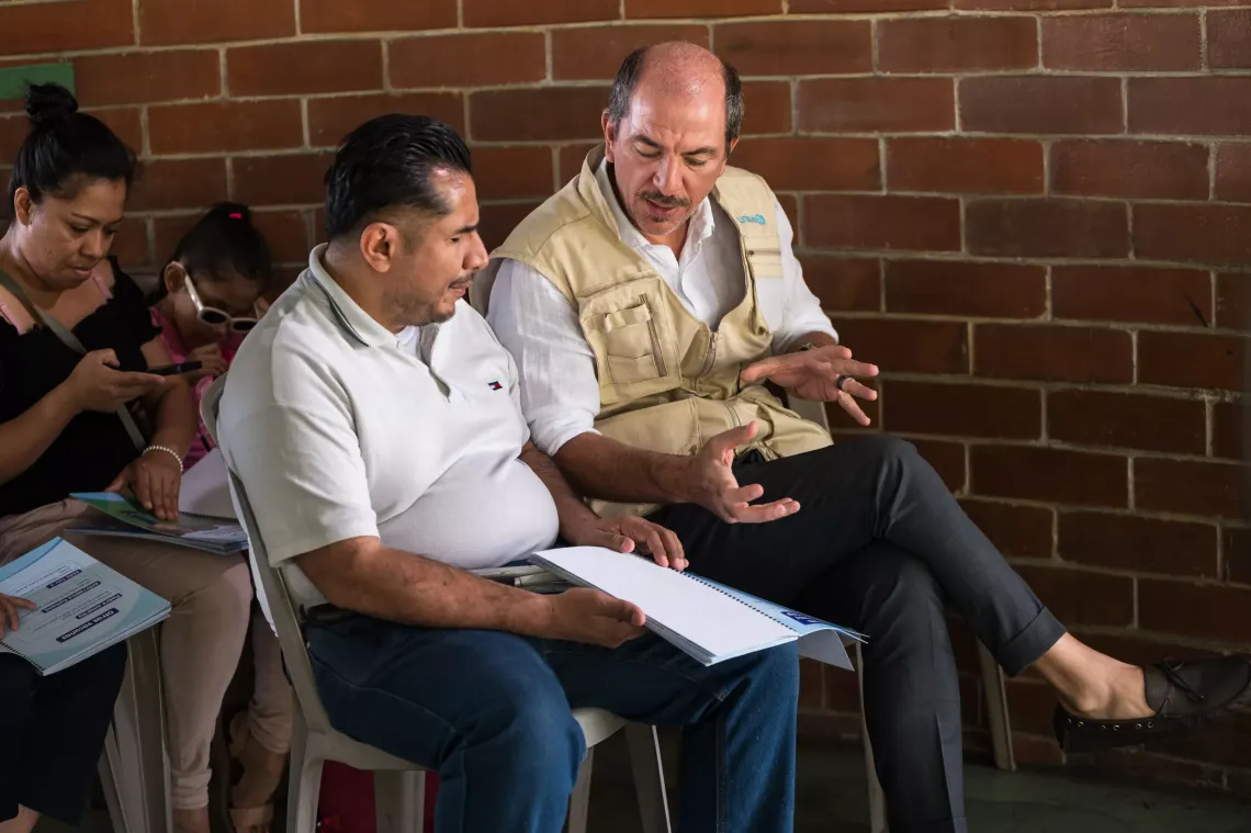 Giovanni D'Amato, Representante Adjunto de UNICEF en El Salvador conversa sobre el documento con una persona con discapacidad visual