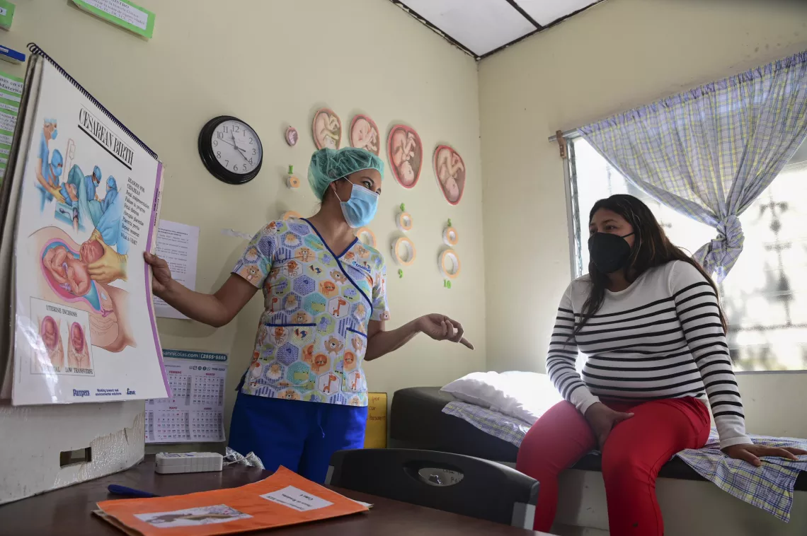 Vilma Elizabeth Gonzalez de Alfaro, licenciada en Cuidado Materno Infantil, encargada del Hogar de espera materna en Los Planes de Renderos, explica temas de salud maternal a D&eacute;bora Maybel Mart&iacute;nez, de 21 a&ntilde;os.