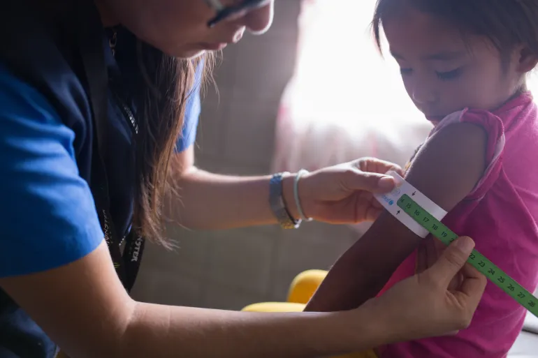 El equipo de nutrici&oacute;n del Ministerio de Salud de Guatemala monitorea a una ni&ntilde;a de la Comunidad Chojol, Alta Verapaz, Guatemala, utilizando una cinta de medici&oacute;n de la circunferencia del brazo para identificar la desnutrici&oacute;n.