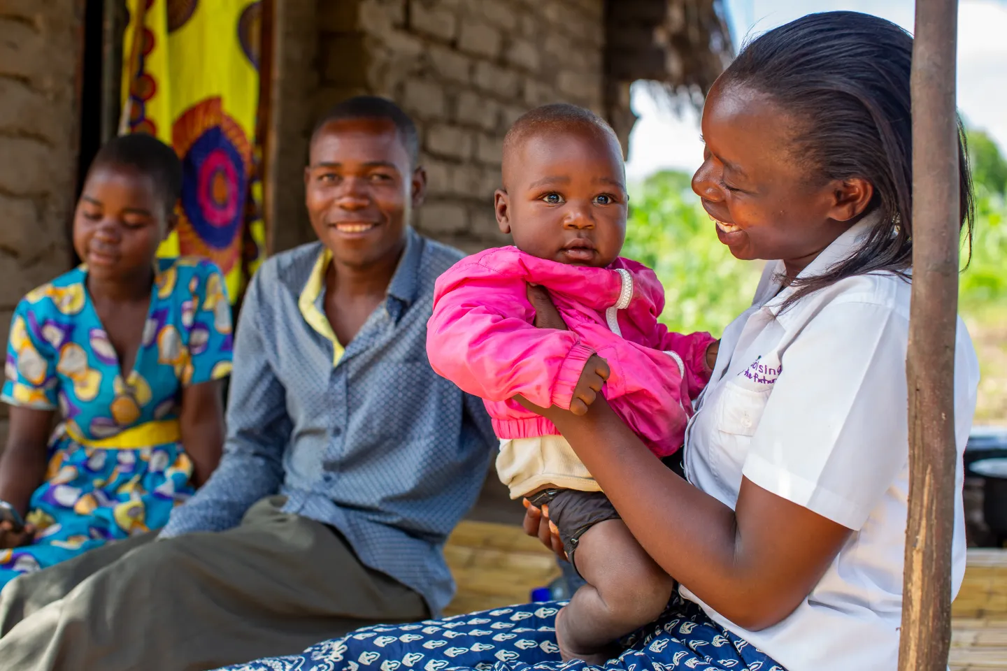A smiling woman holding a young child