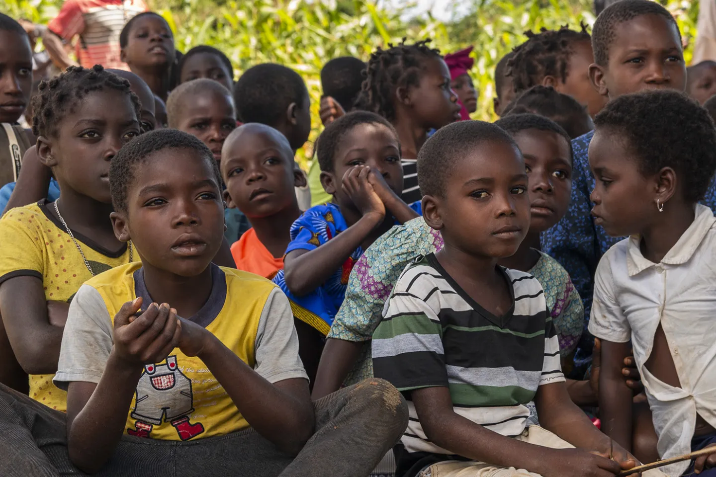Primary school students sitting together on the ground