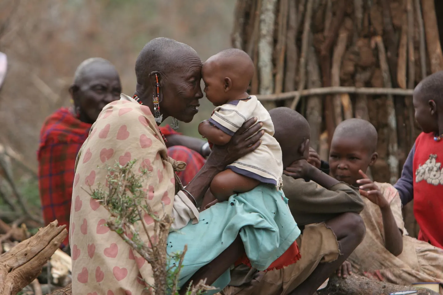 Noorparana Kasino, a nomadic Masai tribeswoman, plays with one of her grandchildren outside the family's temporary home in the village of Kajiado, Kenya.
